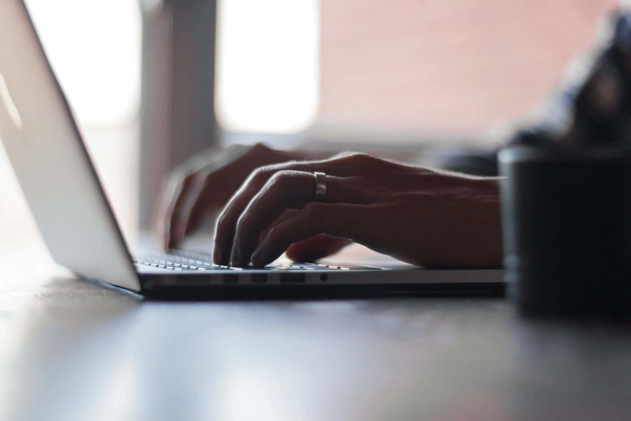 Hands typing on laptop keyboard.