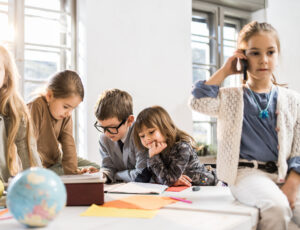 Children working in an office boardroom.