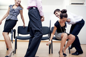 Office workers playing musical chairs.
