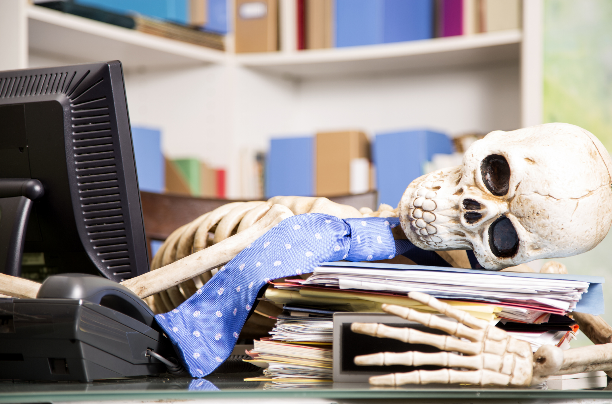 Corpse employee in office showing workplace loyalty.