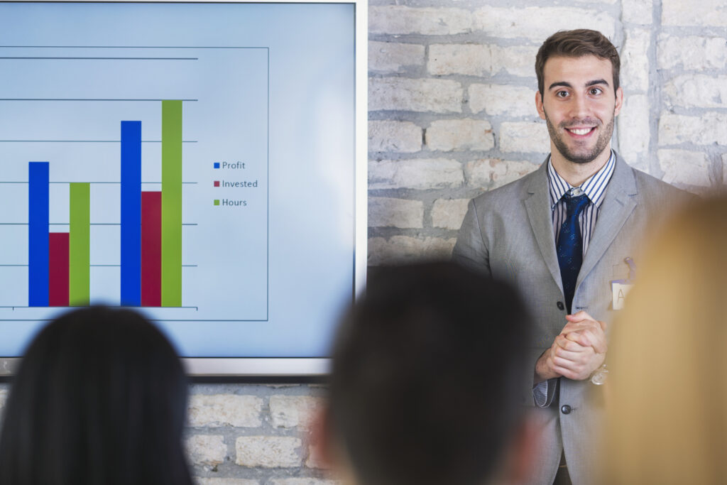 Middle manager confidently presenting a baffling PowerPoint that has held employees captive for four hours.